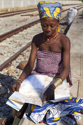 Ndengelengo woman checking a map at the train station, Garganta, Angola. - VEGF00538