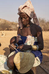 Eine Frau vom Stamm der Mucubal näht einen traditionellen Topf, Tchitundo Hulo, Angola. - VEGF00565