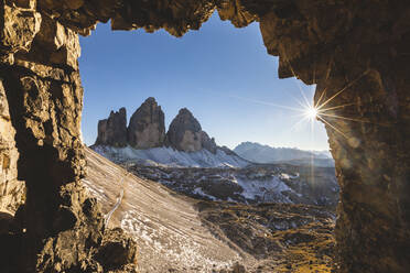 Blick auf die Drei Zinnen von Lavaredo durch eine Höhle an einem sonnigen Tag, Italien - WPEF01828