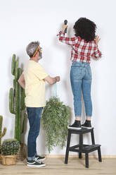 Paar hängt Pflanze an die Wand zu Hause - RTBF01343