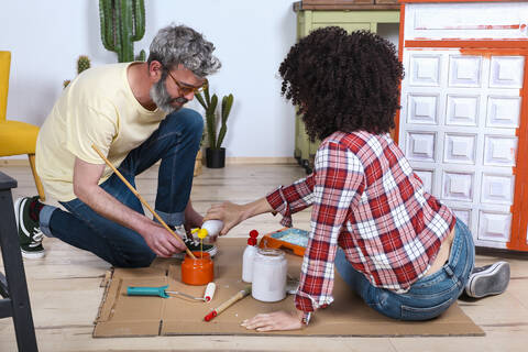 Ehepaar malt Möbel mit Pinsel zu Hause, lizenzfreies Stockfoto