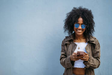 Frau mit Smartphone, blauer Hintergrund - MPPF00018