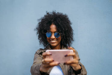 Frau mit Smartphone, blauer Hintergrund - MPPF00019