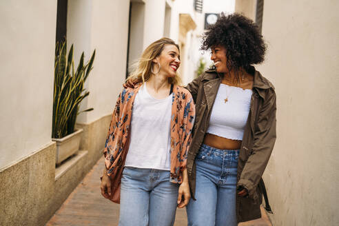 Multicultural laughing women walking in the city - MPPF00023