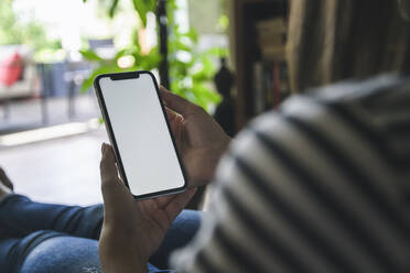 Junge Frau benutzt Smartphone zu Hause - UUF18819