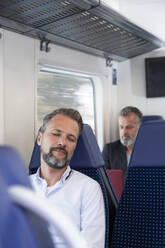 Mature man sitting in a train, sleeping - FKF03554