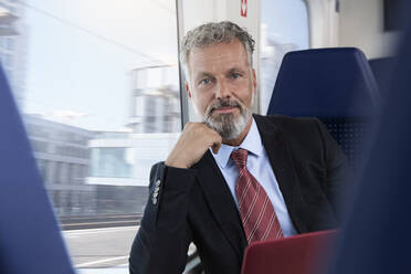Mature businessman traveling by train - FKF03586