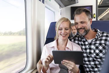 Paar benutzt digitales Tablet in einem Zug - FKF03617