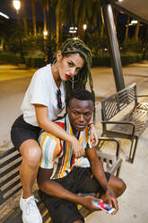 Cool young couple on a bench at night in the city - LJF00782