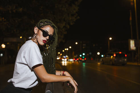 Coole junge Frau auf einer Straße in der Nacht in der Stadt - LJF00786