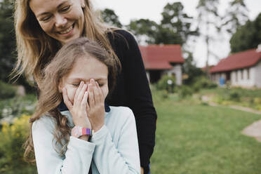 Happy mother and daughter in garden - KMKF01043