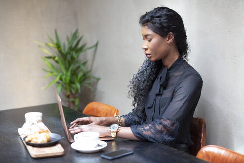Schicke Geschäftsfrau mit Laptop am Tisch in einem Cafe - ALBF00984