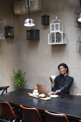 Schicke Geschäftsfrau mit Laptop am Tisch in einem Cafe - ALBF00986