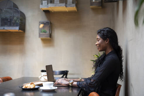 Schicke Geschäftsfrau mit Laptop am Tisch in einem Cafe - ALBF00987