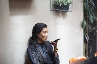 Lächelnde schicke Geschäftsfrau mit Smartphone in einem Café - ALBF00988