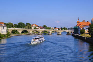 Ausflugsschiff auf der Donau mit Steinbrücke im Hintergrund gegen den Himmel, Regensburg, Oberpfalz, Bayern, Deutschland - SIEF08929