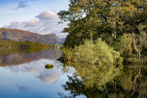 Küstenlinie, Berge und Himmel mit einer perfekten Spiegelung im stillen Wasser des Coniston Water, Lake District National Park, UNESCO-Weltkulturerbe, Cumbria, England, Vereinigtes Königreich, Europa, lizenzfreies Stockfoto