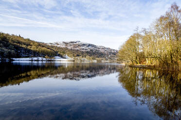 A perfect reflection of snow covered mountains and sky in the still waters of Grasmere, Lake District National Park, UNESCO World Heritage Site, Cumbria, England, United Kingdom, Europe - RHPLF04749