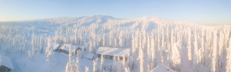 Erhöhter Panoramablick auf Hütten in den schneebedeckten Wäldern, Pallas-Yllastunturi-Nationalpark, Muonio, Lappland, Finnland, Europa - RHPLF05002
