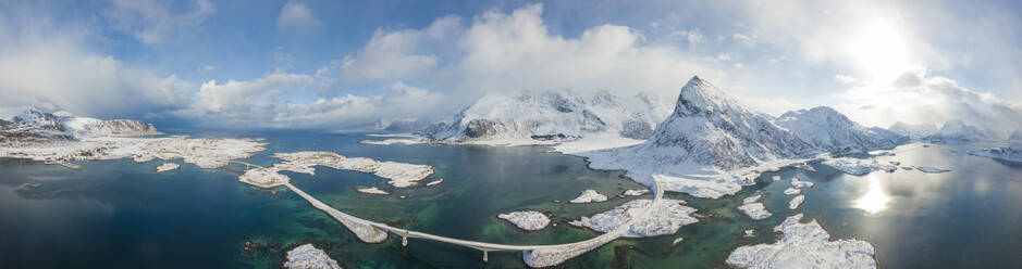 Panoramablick auf den schneebedeckten Gipfel des Volanstinden und die Fredvang-Brücke, Lofoten-Inseln, Nordland, Norwegen, Europa - RHPLF05013