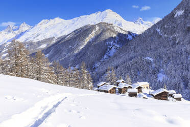 Eine Spur im Schnee führt zu den traditionellen Hütten von Blatten, Zermatt, Kanton Wallis, Schweiz, Europa - RHPLF05418
