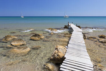 Holzsteg und klares türkisfarbenes Meer mit Yachten am Strand von Provatas, Milos, Kykladen, Ägäisches Meer, Griechische Inseln, Griechenland, Europa - RHPLF05444