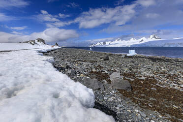 Expeditionstouristen spazieren am Ufer von Half Moon Island, Blick auf Livingston Island, blauer Himmel, Süd-Shetland-Inseln, Antarktis, Polarregionen - RHPLF05504