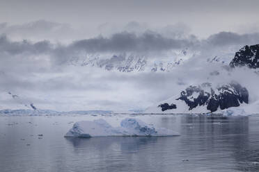 Low lying mist and clouds over mountains, glaciers and icebergs of Paradise Bay, calm waters, Antarctic Peninsula, Antarctica, Polar Regions - RHPLF05514