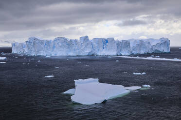 Großer blauer Tafeleisberg, kleiner Eisberg und Küste des Errera-Kanals, Danco-Küste, Antarktische Halbinsel, Antarktis, Polarregionen - RHPLF05684