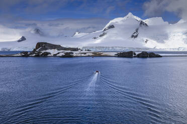 Touristen in einem Zodiac-Boot nähern sich der Halbmondinsel, Bergkulisse der Livingston-Insel, Süd-Shetland-Inseln, Antarktis, Polarregionen - RHPLF05688