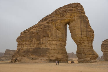 Einheimische stehen im Riesenbogen des Elefantenfelsens, Al Ula, Saudi-Arabien, Naher Osten - RHPLF05709