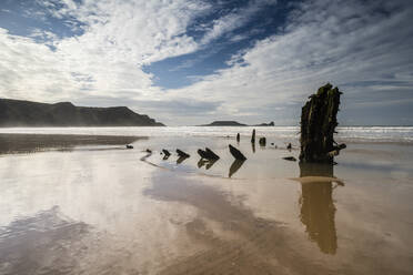 Helvetia-Schiffswrack und Wolken, die sich im nassen Sand spiegeln, bei Ebbe, Rhossili Bay, Gower Peninsula, Südwales, Vereinigtes Königreich, Europa - RHPLF05732