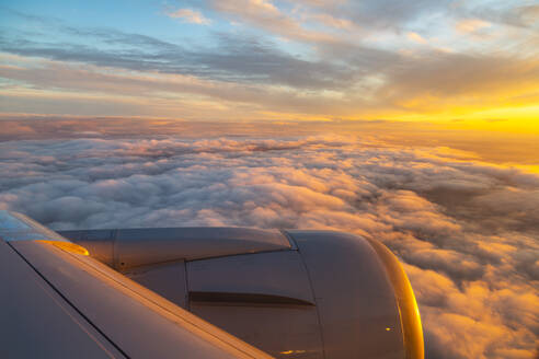 Allgemeiner Blick aus dem Flugzeugfenster auf Flugzeugflügel und Sonnenaufgang über England, Vereinigtes Königreich, Europa - RHPLF05806