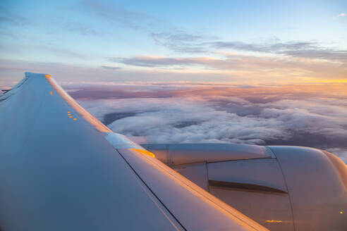 Allgemeiner Blick aus dem Flugzeugfenster auf Flugzeugflügel und Sonnenaufgang über England, Vereinigtes Königreich, Europa - RHPLF05808
