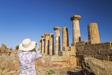 Visitor photographing the Temple of Heracles (Temple of Hercules), UNESCO World Heritage Site, Valley of the Temples, Agrigento, Sicily, Italy, Mediterranean, Europe - RHPLF05905