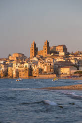 View from beach along water's edge to the town and UNESCO World Heritage Site listed Arab-Norman cathedral, sunset, Cefalu, Palermo, Sicily, Italy, Mediterranean, Europe - RHPLF05906