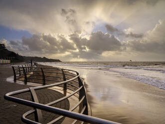 Schimmernder Sand und Geländer in warmem Licht Exmouth, Devon, England, Vereinigtes Königreich, Europa - RHPLF06320