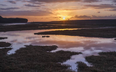 Hundespaziergänger unterhalten sich bei Sonnenaufgang mit perfekten Reflektionen auf dem Fluss Otter in Budleigh Salterton, Devon, England, Vereinigtes Königreich, Europa - RHPLF06347