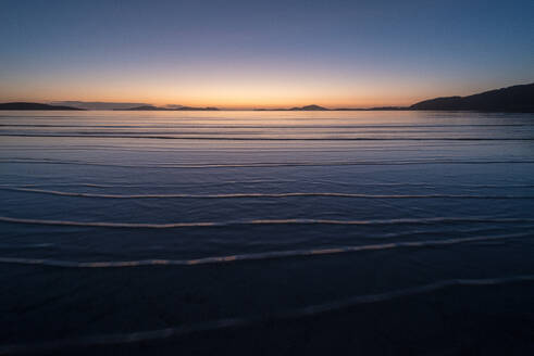 Wintersonnenaufgang bei Flut, Traigh Mhor, der als Flughafen von Barra genutzte Strand bei Ebbe, Barra, Äußere Hebriden, Schottland, Vereinigtes Königreich, Europa - RHPLF06484