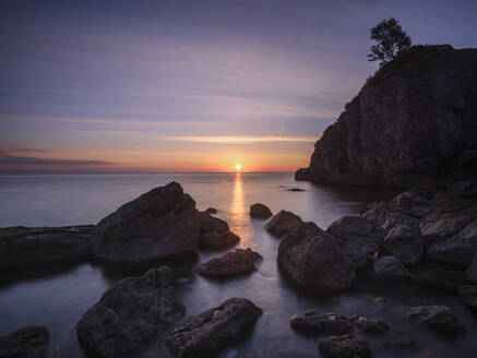 Ein farbenfroher Sonnenaufgang über Torbay mit warmem Licht auf den Felsen, Babbacombe, Torquay, Devon, England, Vereinigtes Königreich, Europa - RHPLF06608