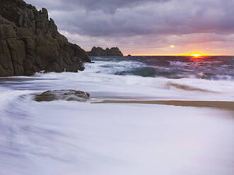 Frühmorgens am Strand mit Blick auf den Logan Rock bei Porthcurno, Cornwall, England, Vereinigtes Königreich, Europa - RHPLF06636