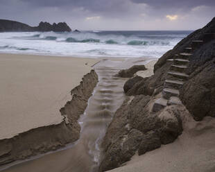 Stürmische Bedingungen am Strand mit Blick auf den Logan Rock in Porthcurno, Cornwall, England, Vereinigtes Königreich, Europa - RHPLF06637