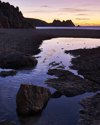 Frühmorgens am Strand mit Blick auf den Logan Rock bei Porthcurno, Cornwall, England, Vereinigtes Königreich, Europa - RHPLF06638