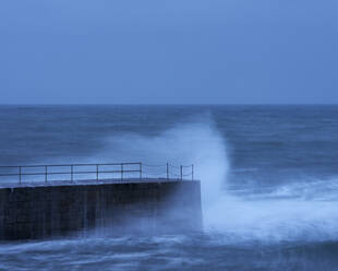 Wave in a storm strikes the breakwater at Porthleven in Cornwall, England, United Kingdom, Europe - RHPLF06639