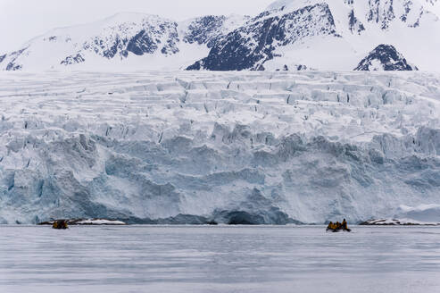 Tourist auf Schlauchboot auf dem Fuglefjorden, Spitzbergen, Svalbard, Arktis, Norwegen, Europa, Norwegen. - RHPLF06854