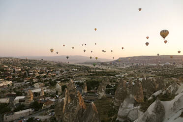 Heißluftballons fliegen über die Landschaft bei klarem Himmel im Goreme National Park, Kappadokien, Türkei - KNTF03275