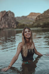 Junge blonde Frau beim Baden in einem See im Sommer, am Abend - ACPF00622