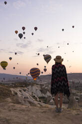 Junge Frau und Heißluftballons am Abend, Goreme, Kappadokien, Türkei - KNTF03296