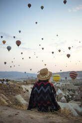 Junge Frau und Heißluftballons am Abend, Goreme, Kappadokien, Türkei - KNTF03298