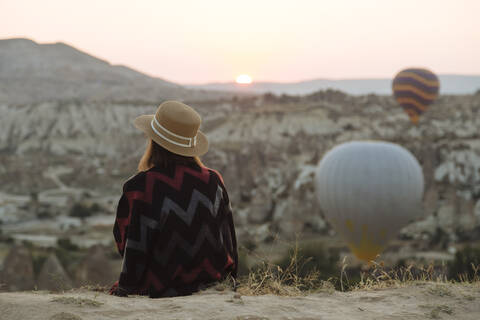 Junge Frau und Heißluftballons am Abend, Goreme, Kappadokien, Türkei, lizenzfreies Stockfoto